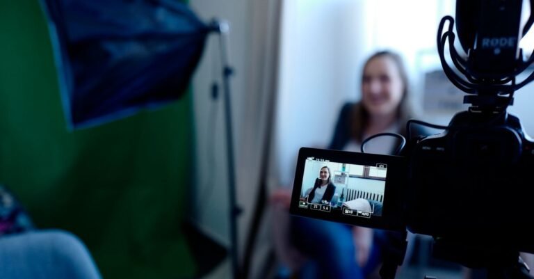 Woman being recorded in a professional studio setup, using video camera and lighting equipment.