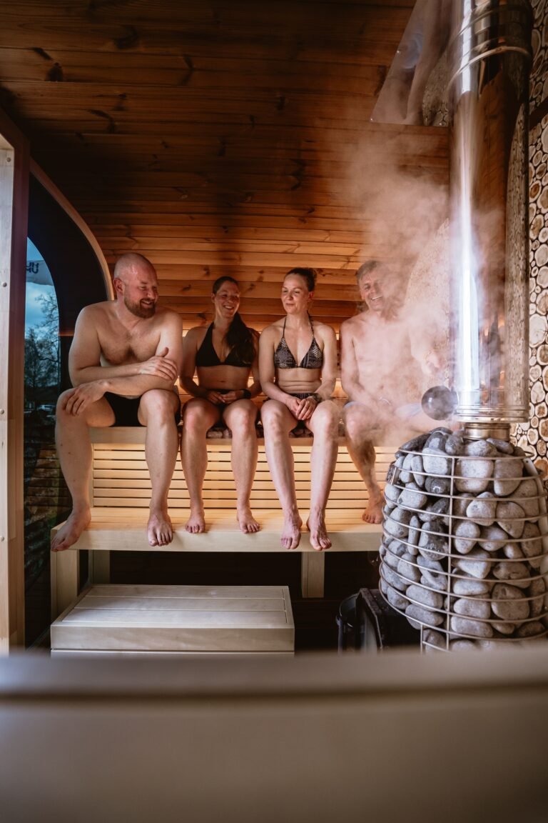 Sauna Group enjoying a relaxing sauna with steam from wood stove and stones.